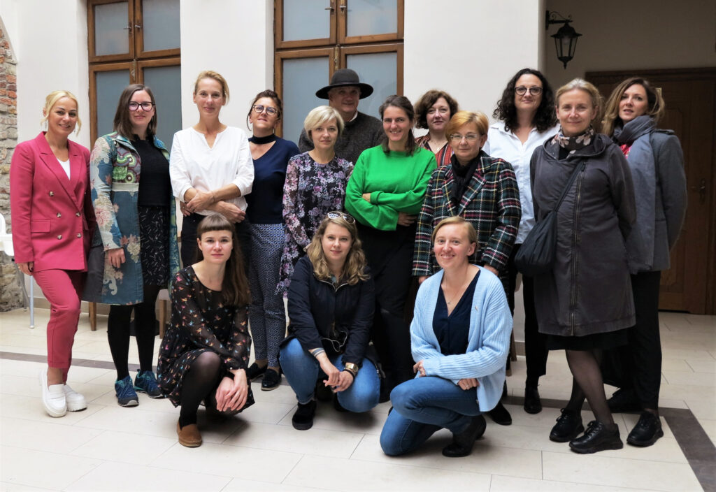 Zdjęcie grupowe uczestników warsztatów, którzy przyjaźnie uśmiechają się do zdjęcia.