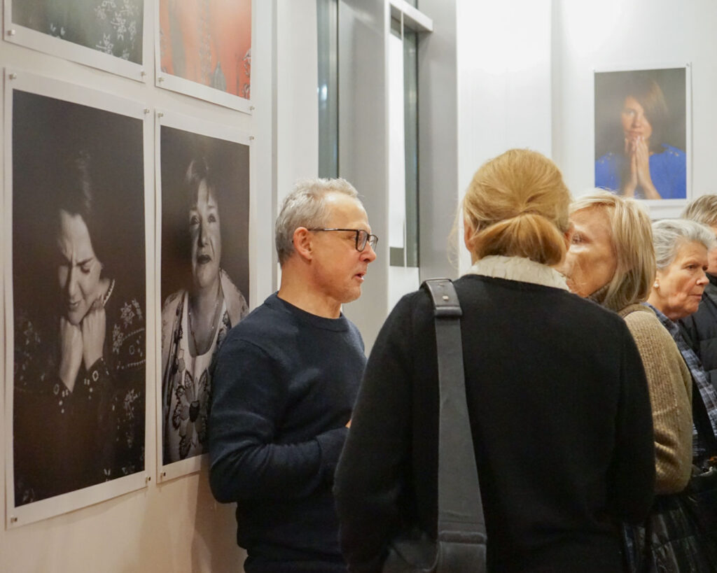 Goście wystawy oglądają fotografie portretowe ukraińskich kobiet prezentowane w sali.